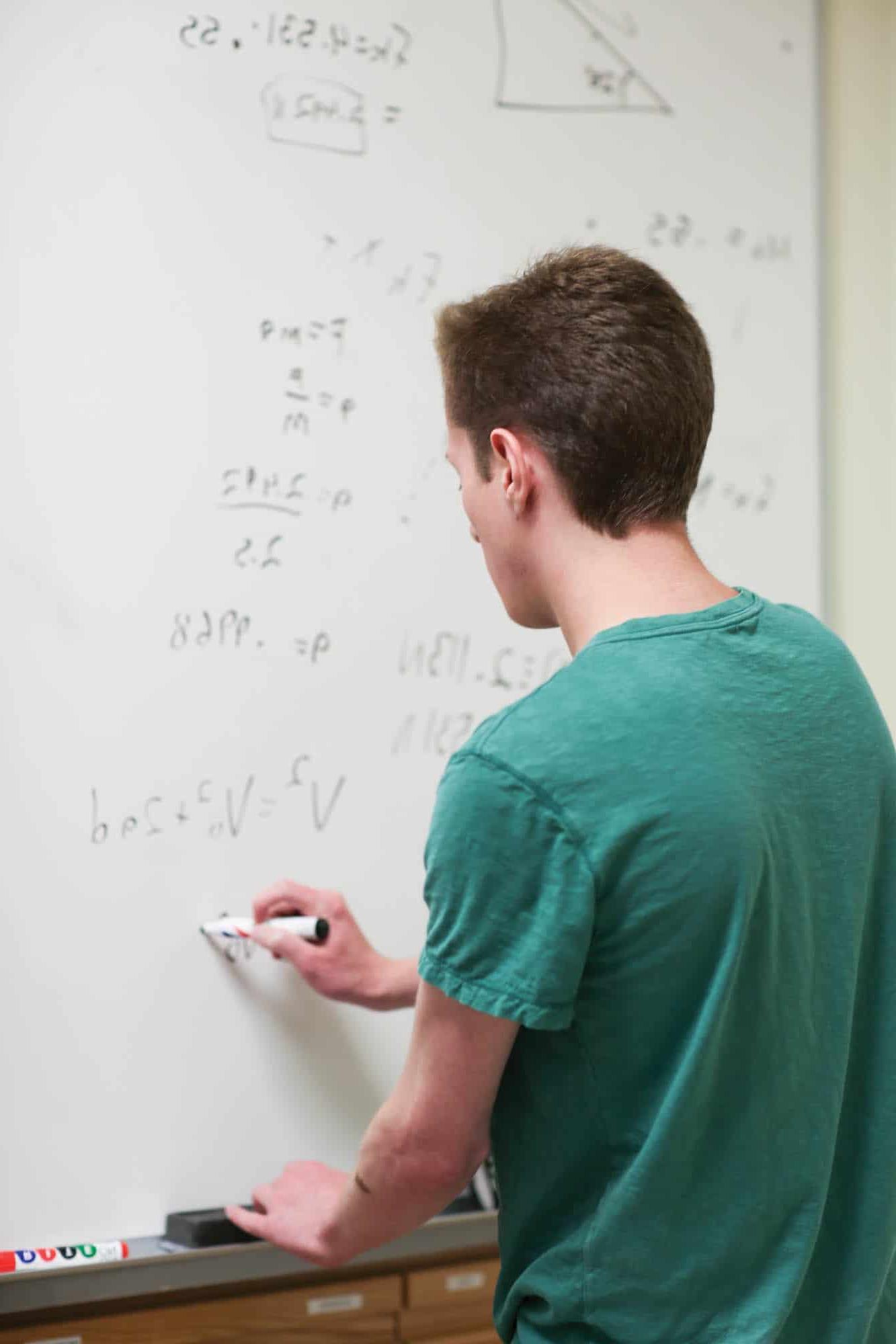 student doing mathmatics on class board