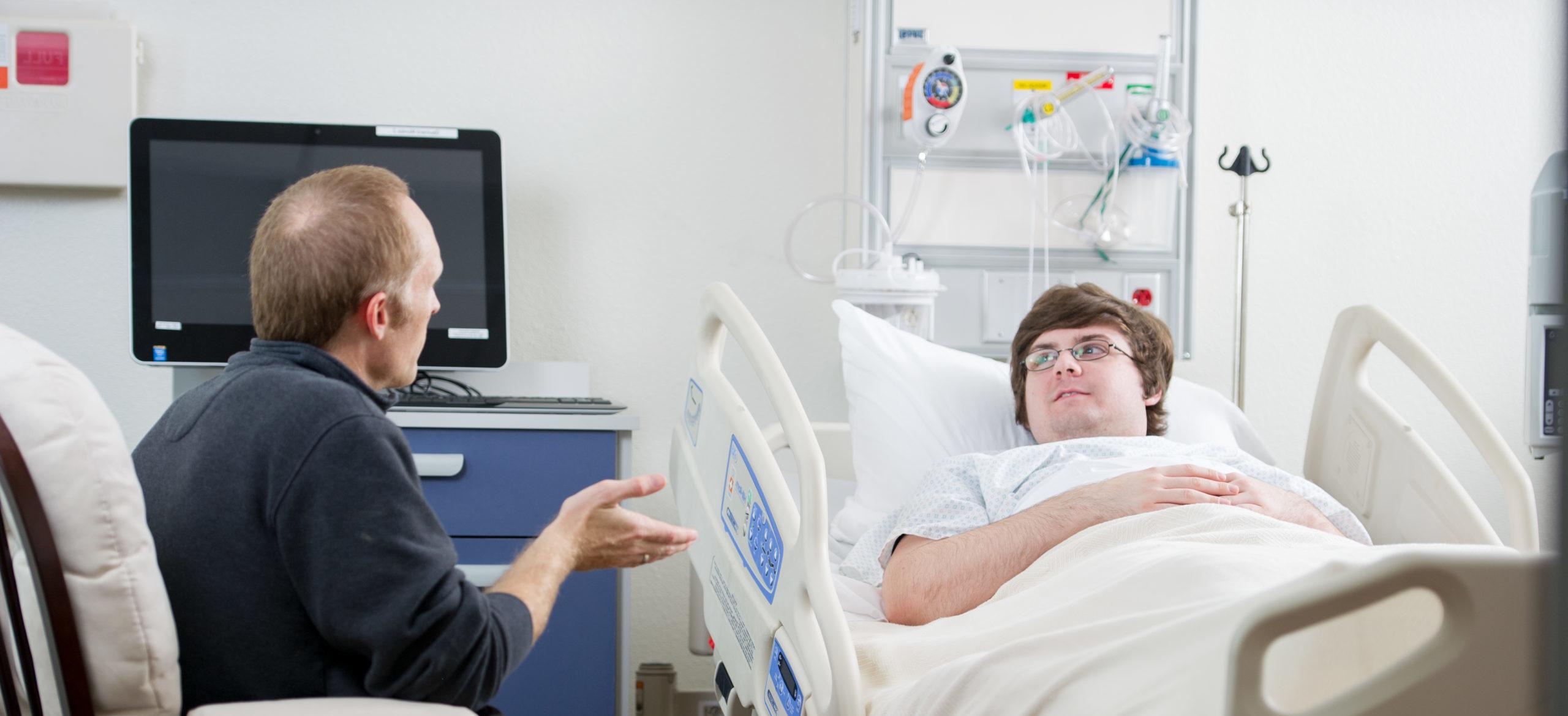 Social worker talking to man in the hospital.