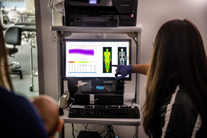 Students analyzing the result of a fitness test on a computer screen.
