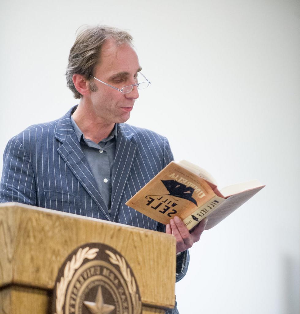 Man reading book from podium.