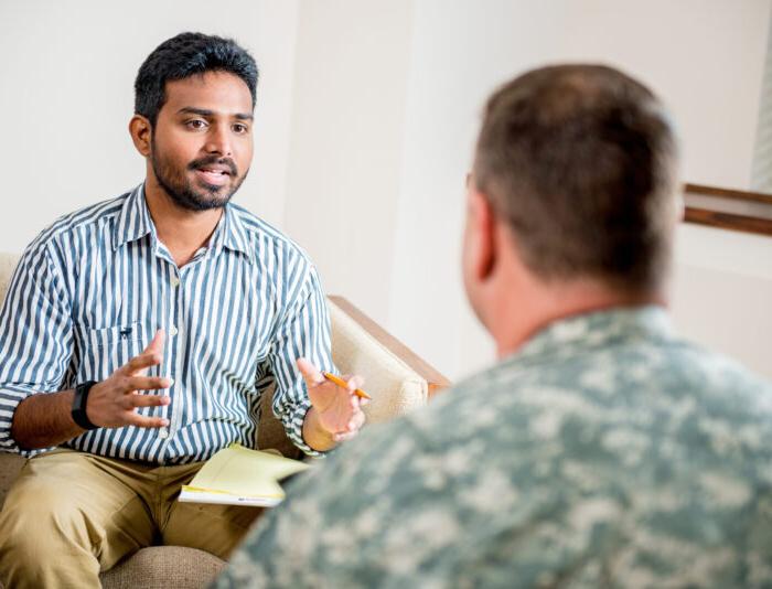 Social worker talking to man in the military.