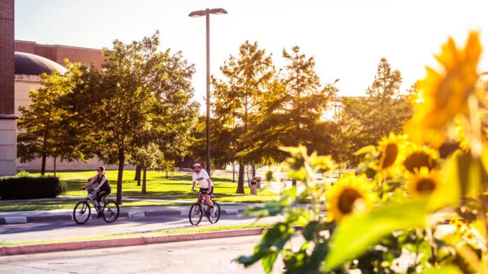 A picture of students riding a bike on campus