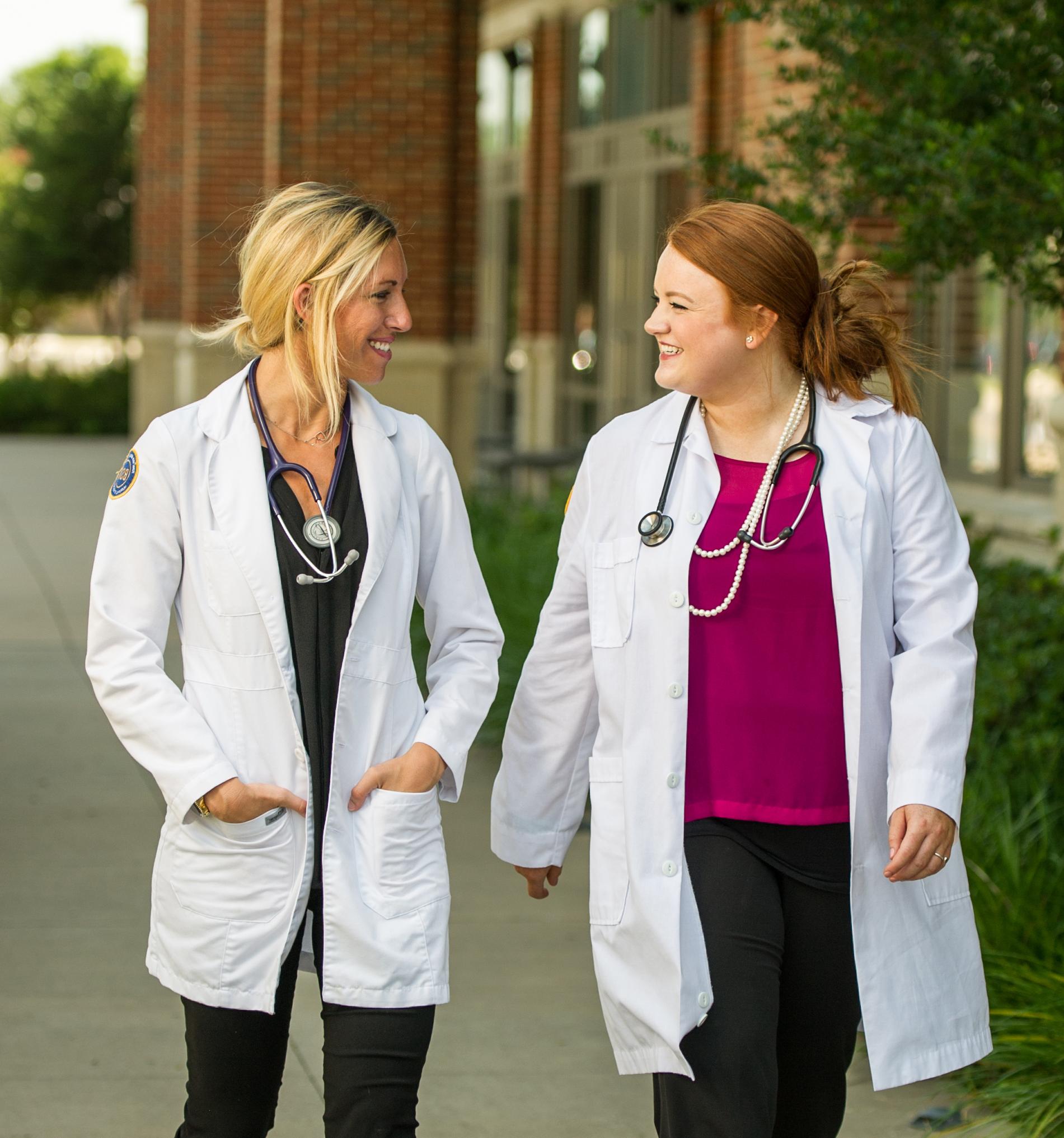 Two nursing student talking to one another.