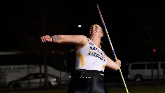 Athlete leans back, preparing to throw the javelin.